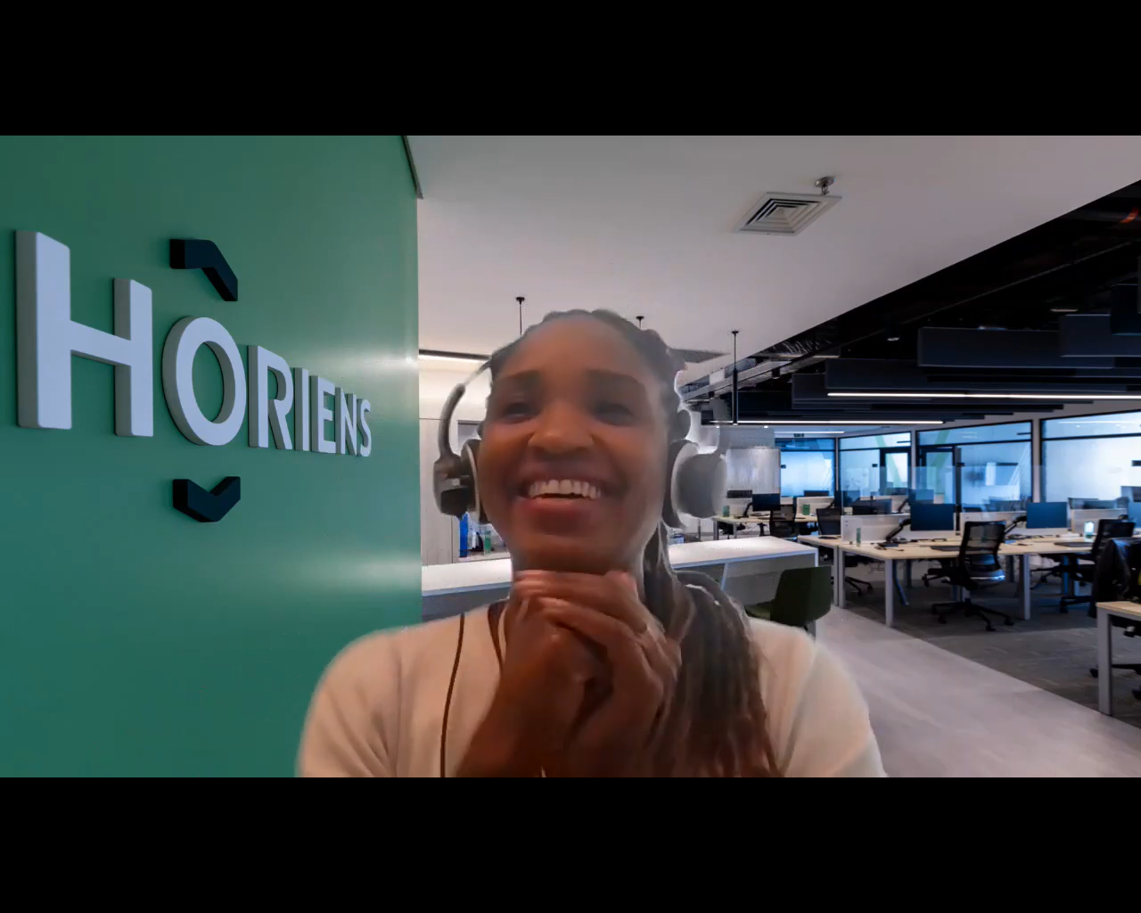 Um mulher negra sorri em uma reunião online