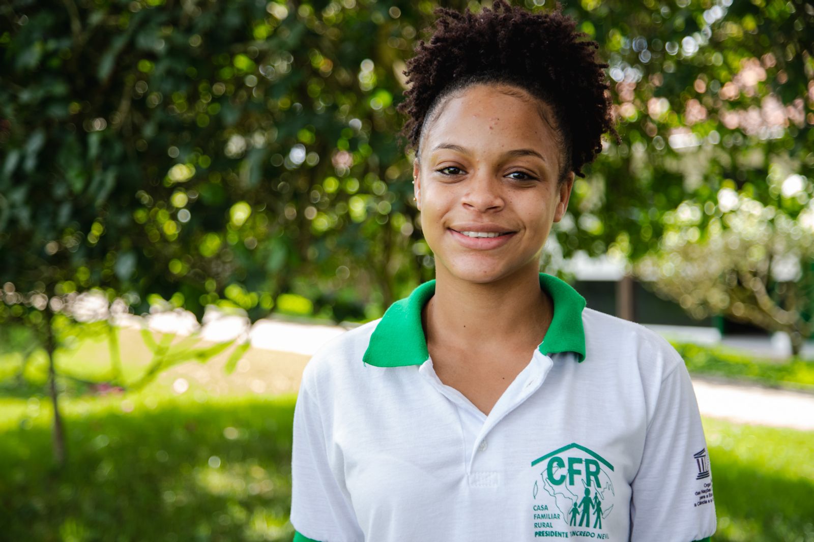 Uma jovem negra com uniforme escolar sorri