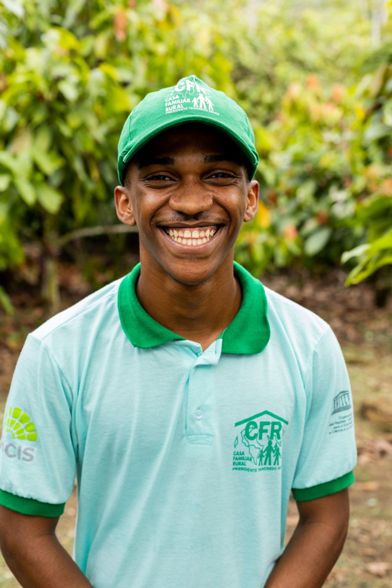 Um jovem negro usando boné sorri 